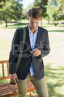 Casual businessman texting on smartphone in park