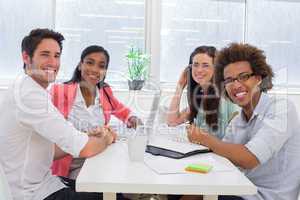 Business people having a meeting together smile at camera