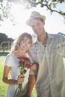 Attractive blonde holding roses standing with partner smiling at