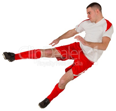 Fit football player playing and kicking