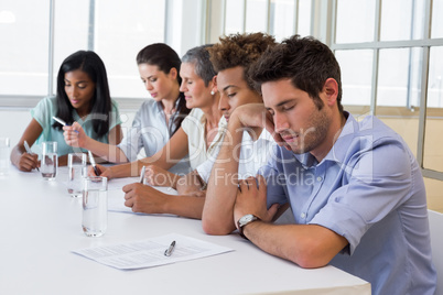 Casual businessman falling asleep during meeting