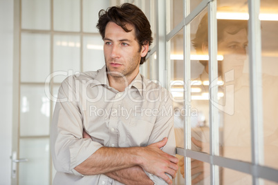 Casual worried businessman leaning on window