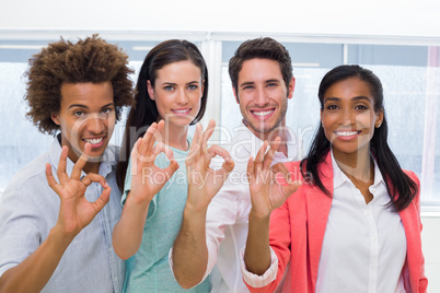 Group of workers giving OK gesture to camera
