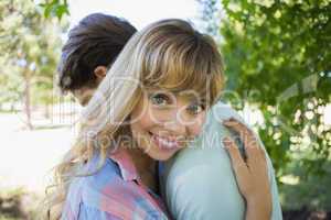 Loving young couple standing together in the park woman smiling