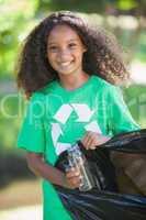 Young environmental activist smiling at the camera picking up tr