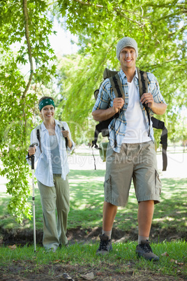 Happy active couple going on a hike smiling at camera