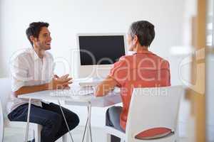 Casual business people talking at desk and smiling