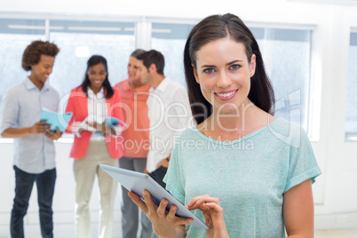 Businesswoman using tablet and smiling at camera