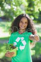 Young environmental activist smiling at the camera holding a pot