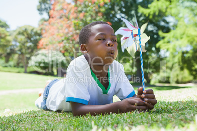 Little boy blowing pinwheel in the park