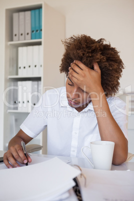 Casual stressed businessman writing at his desk