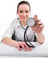 Businesswoman typing on a keyboard and holding stethoscope