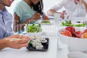 Business people enjoying sushi and salad for lunch