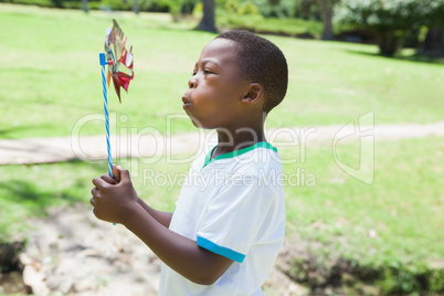 Little boy blowing pinwheel in the park