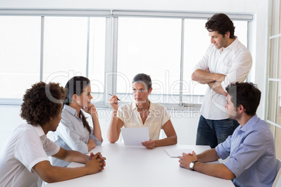 Serious businesswoman speaking to her coworkers