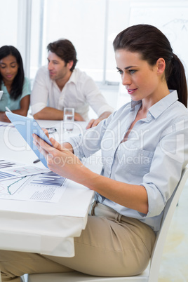 Pretty businesswoman using tablet device in business meeting