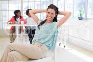 Businesswoman relaxing with colleagues behind her