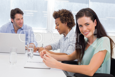 Casual businesswoman smiling at camera during meeting