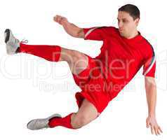 Fit football player jumping and kicking