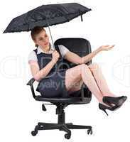 Businesswoman holding umbrella sitting on swivel chair