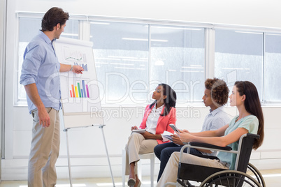 Attractive businessman presenting graph to coworkers