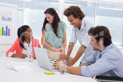 Casual business team having a meeting using laptop