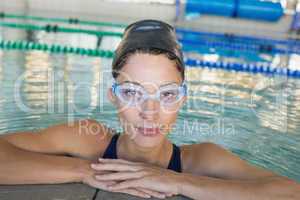 Fit swimmer looking at camera in the swimming pool