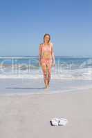 Fit woman in bikini walking from the sea