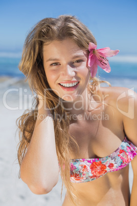 Beautiful happy blonde with flower hair accessory on the beach