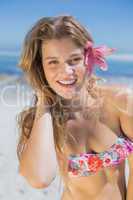 Beautiful happy blonde with flower hair accessory on the beach