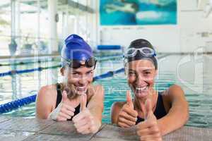 Female swimmers smiling at camera in the swimming pool