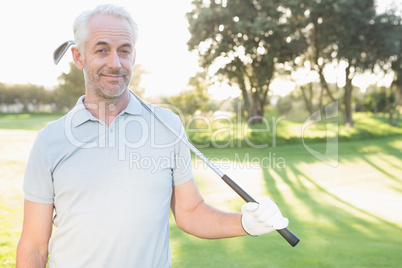 Smiling handsome golfer looking at camera