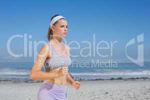 Sporty focused blonde jogging on the beach