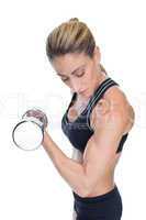 Female bodybuilder holding a large dumbbell looking at bicep