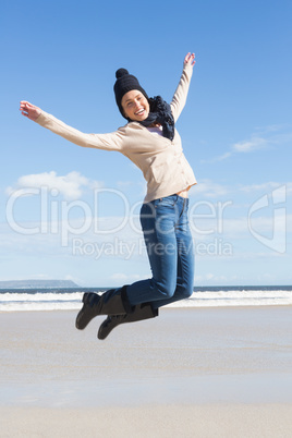 Pretty blonde in jeans leaping on the beach