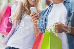 Cute young couple on shopping trip looking at smartphone