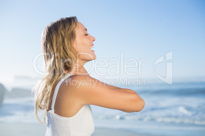 Pretty blonde standing at the beach in white sundress