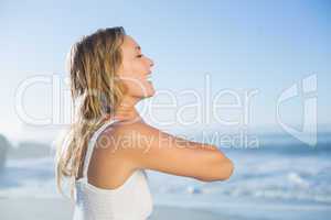 Pretty blonde standing at the beach in white sundress