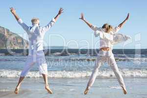 Couple jumping on the beach together