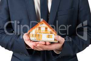 Businessman holding miniature house model