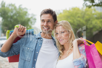 Hip young couple holding shopping bags