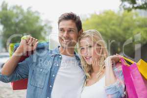 Hip young couple holding shopping bags