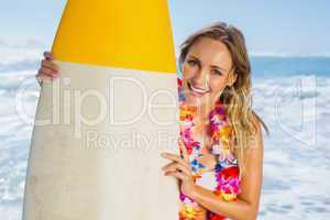 Smiling blonde surfer in white bikini and garland on the beach