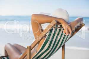 Slim woman relaxing in deck chair on the beach