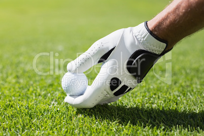 Golfer placing golf ball on tee