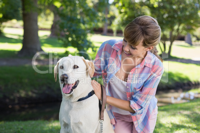 Cute blonde with her labrador dog in the park