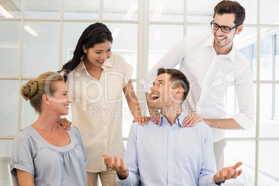 Casual business team congratulating colleague