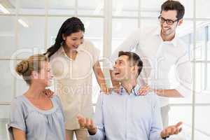 Casual business team congratulating colleague