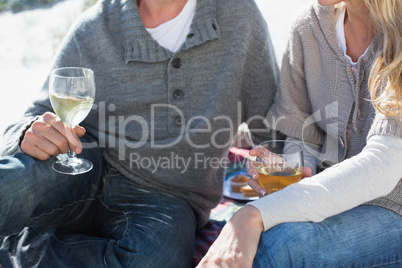 Couple enjoying white wine on picnic at the beach