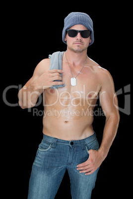 Muscular man posing in blue jeans hat and sunglasses